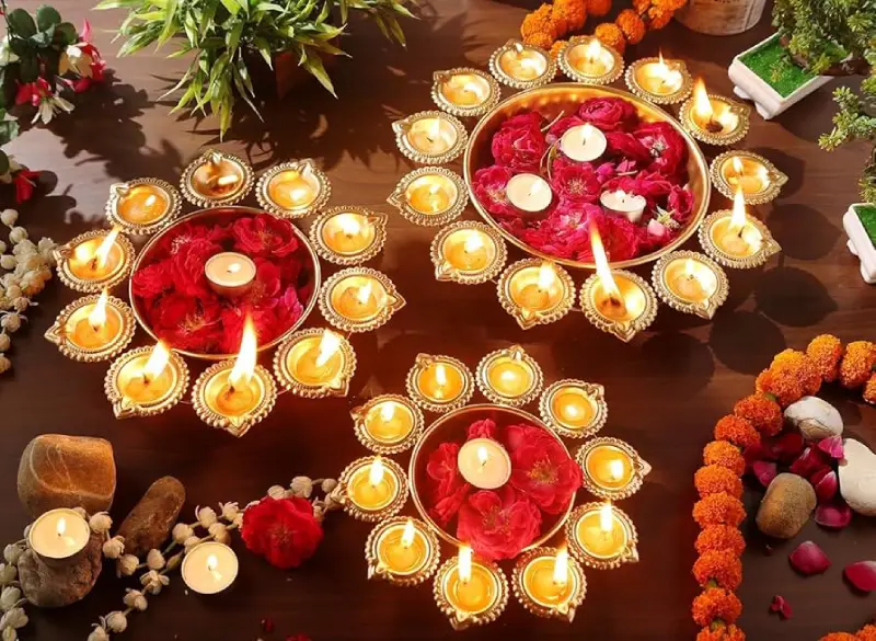 Glass or metal water bowl with wax diyas and flowers